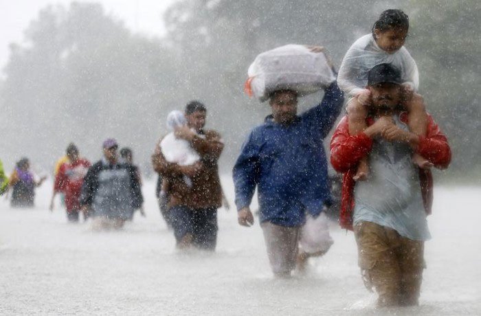 Dòng người lội bộ qua dòng nước lũ do siêu bão Harvey gây ra
