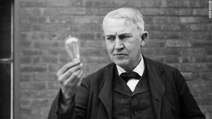 Nhà vật lý Thomas Edison (1847 - 1931) đang nhìn một chiếc bóng đèn.