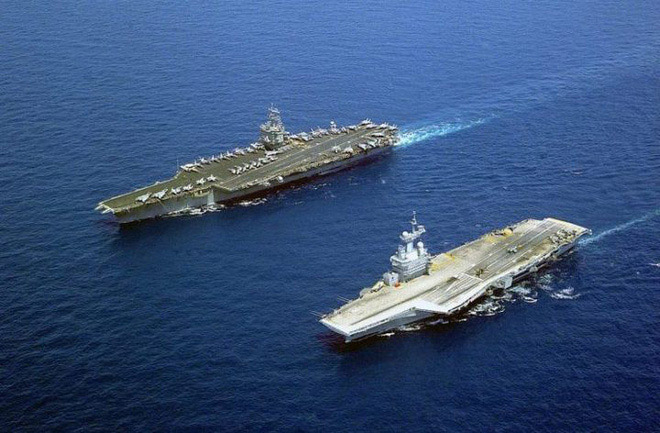 USS Enterpirse (trái) là tàu sân bay chạy bằng năng lượng hạt nhân đầu tiên và Charles de Gaulle (phải) đang di chuyển trên biển Địa Trung Hải vào ngày 16/5/2001