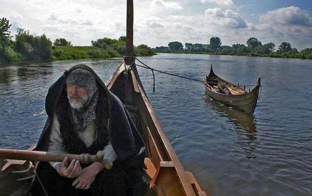 Một người đàn ông lái một con tàu mô phỏng tàu của người Viking.