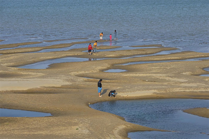 Các du khách đứng trên bãi cát ở sông Mê Kông thuộc tỉnh Nakhon Phanom, đông bắc Thái Lan hôm thứ Tư, 4/12.