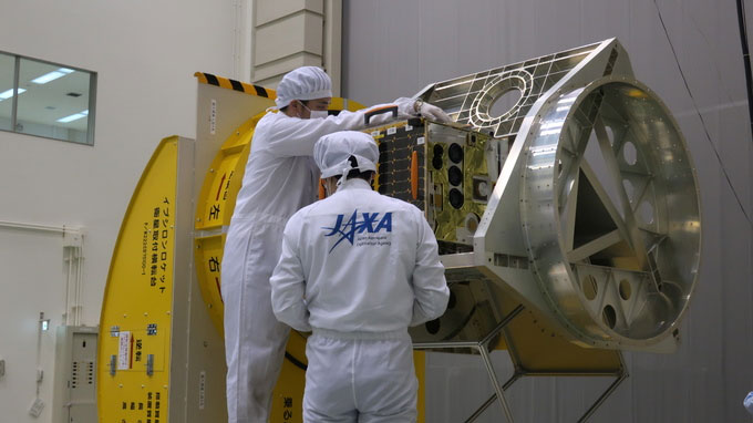Các kỹ sư JAXA đang lắp đặt thử nghiệm vệ tinh vào bộ gá đặt trong tên lửa. 