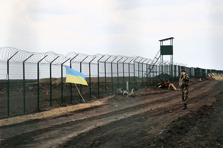 Một sĩ quan bảo vệ biên giới Ukraine nói chuyện qua điện thoại cạnh hàng rào ở biên giới Ukraine - Nga