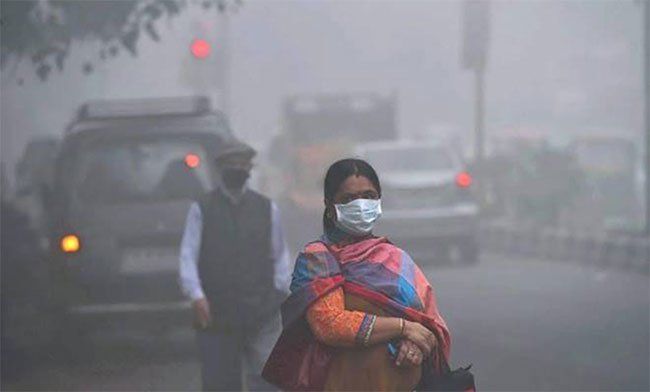 Một phụ nữ Ấn Độ mang khẩu trang để đối phó với bầu không khí ô nhiễm mịt mù