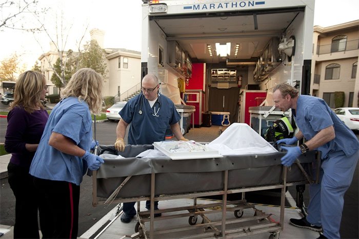 Một bệnh nhân vừa qua đời đang được các kỹ thuật viên chuẩn bị để đưa vào bể bảo quản xác