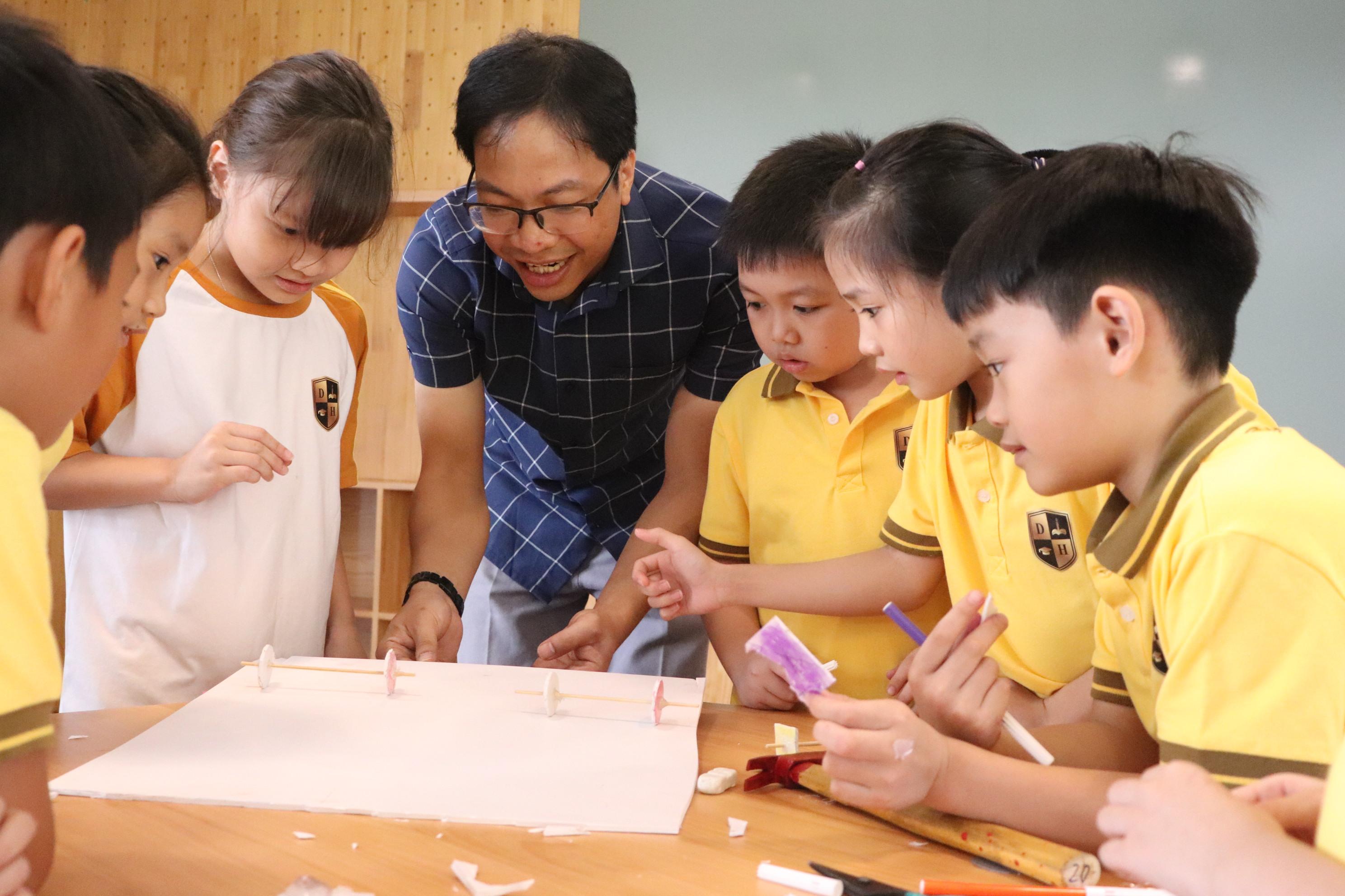 Thầy Hà Văn Lanh và các học sinh lớp 3 Trường tiểu học Dạ Hợp, TP Hòa Bình, trong giờ học về lực cản trong chuyển động. Ảnh: HTL