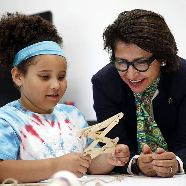 Bà Sylvia Acevedo giúp một em nhỏ tham gia Tổ chức Girl Scouts
